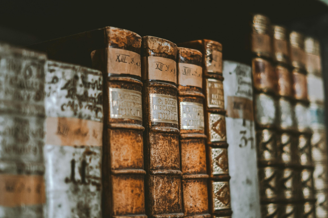 Old books on a shelf with a brown background